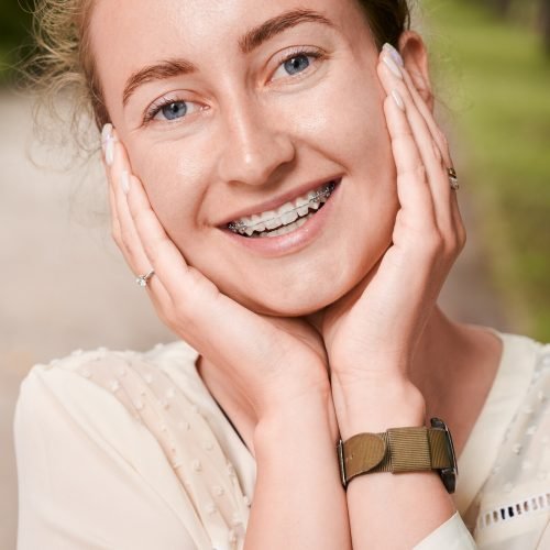 Joyful young woman showing teeth with braces.